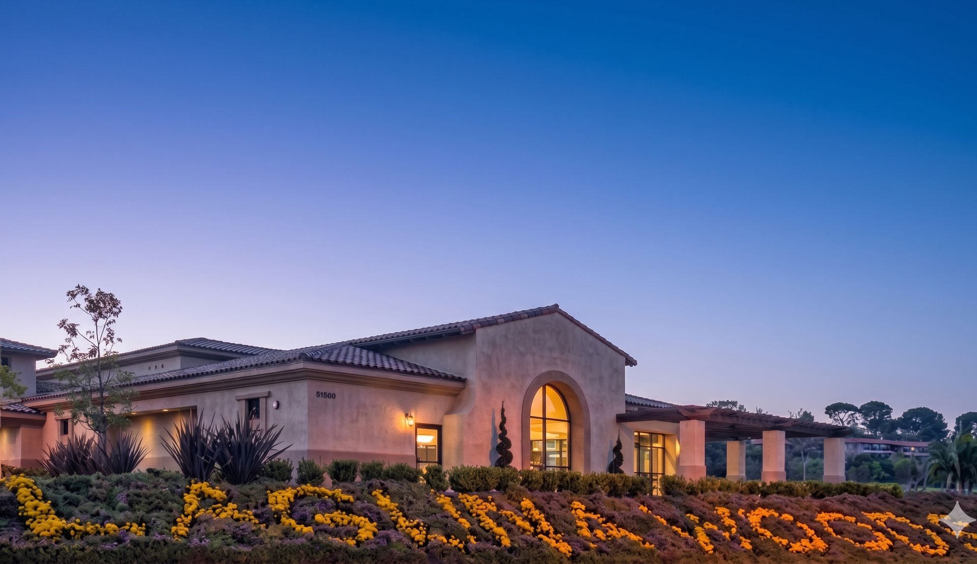 Laguna Woods Village: Clubhouse 7 at dusk with the flower sign